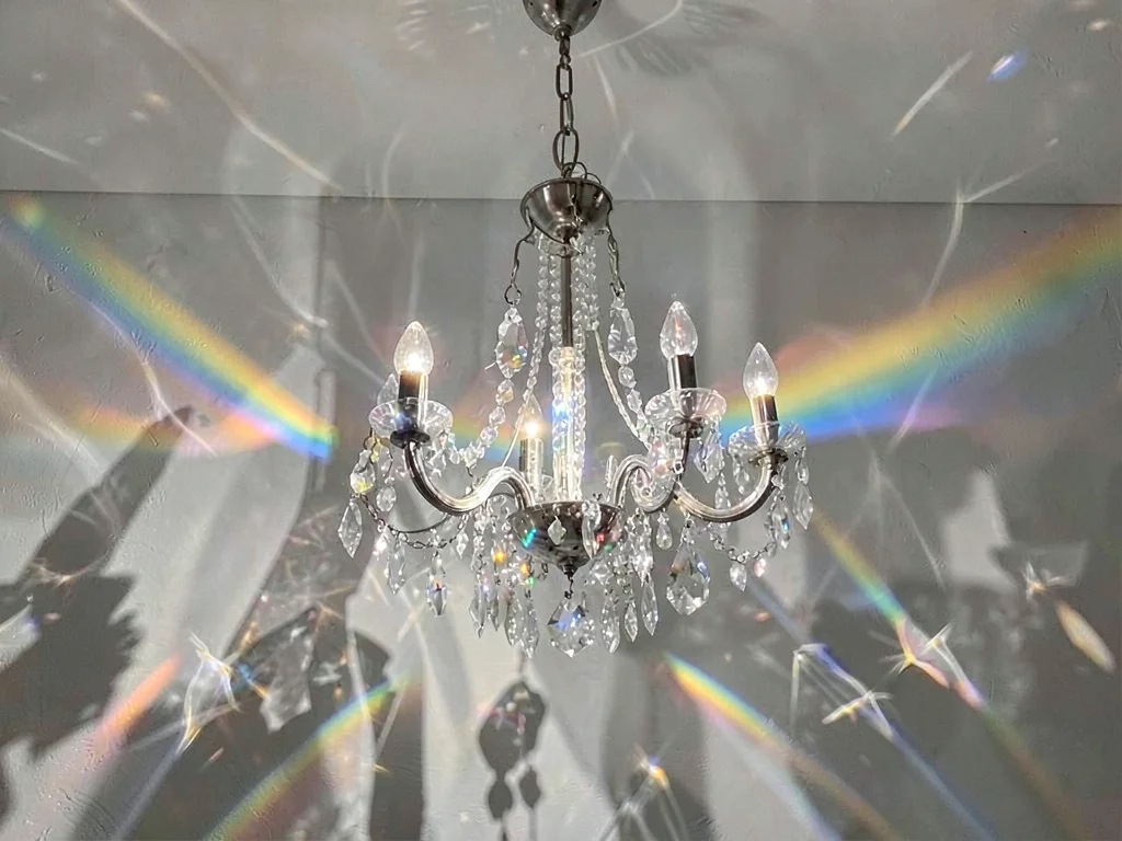 Chandelier crystal creating spectrum scatter on wall