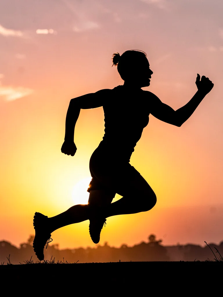 Runner silhouetted against sunrise