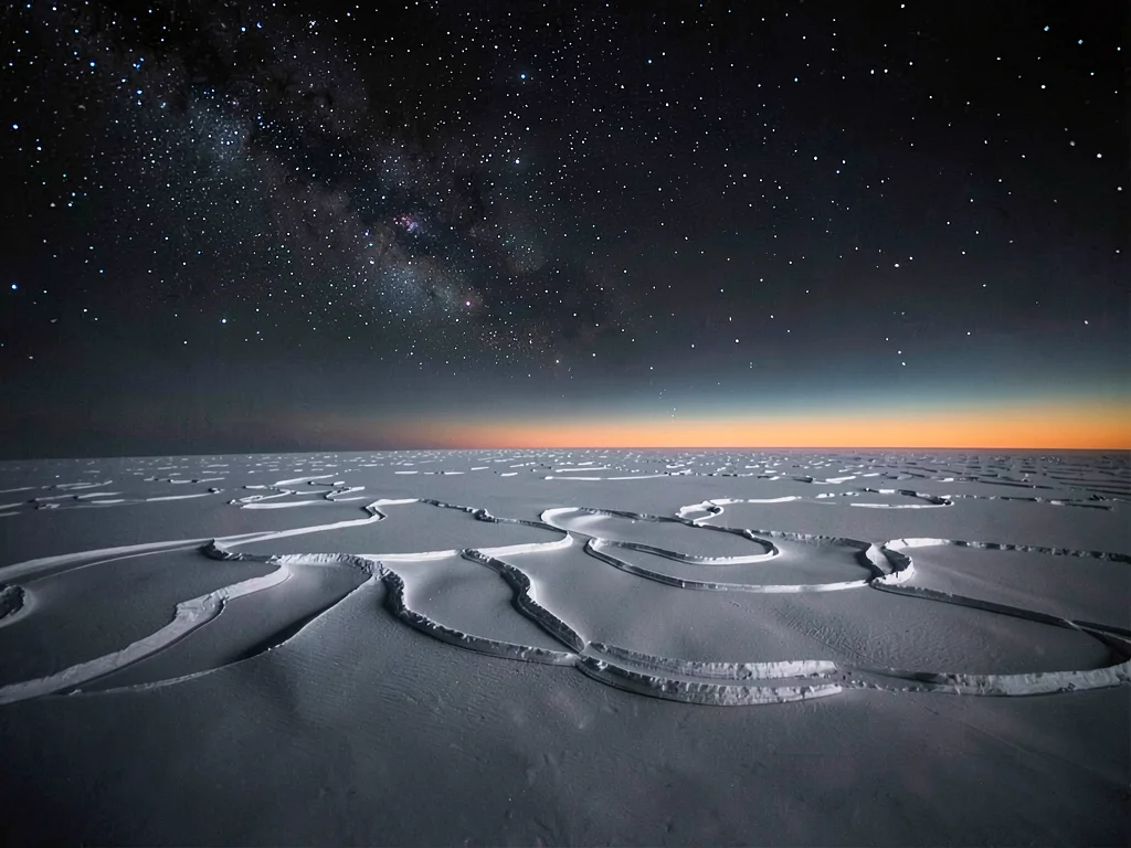 Wind-carved snow patterns under space-dark sky at 5000m