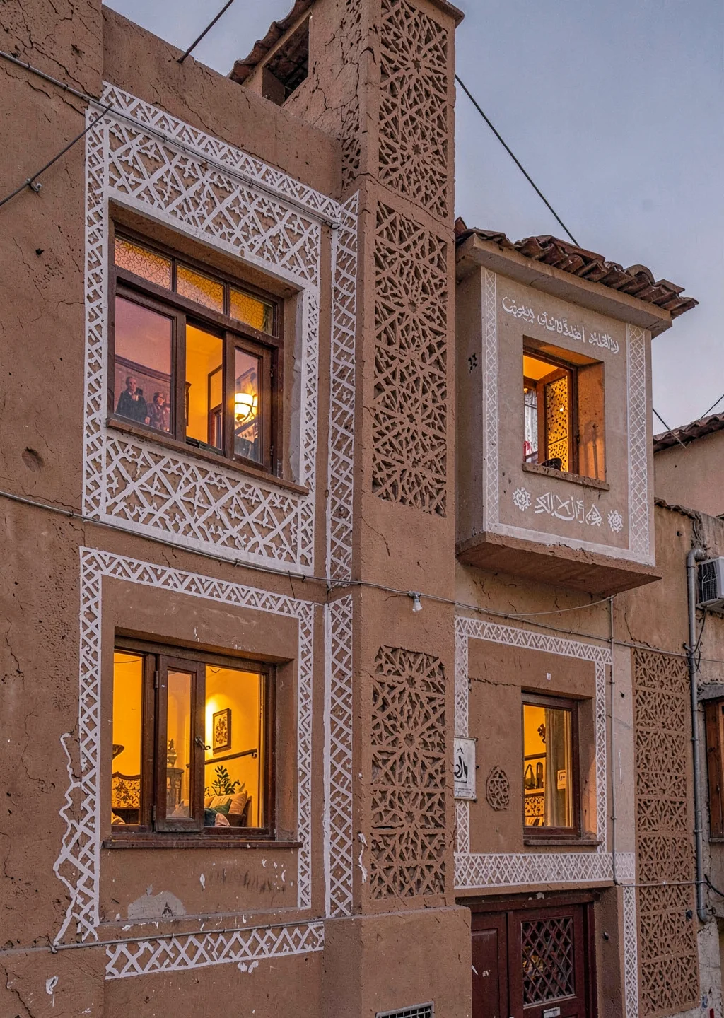 Colored light through qamariya windows in Sana'a, Yemen, gingerbread facade exte