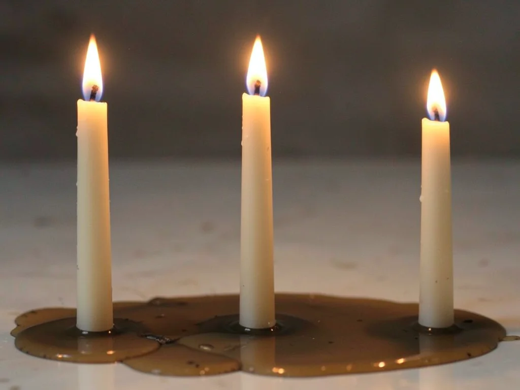 Candle shown at seven stages of burning, tallest to puddle, time compressed