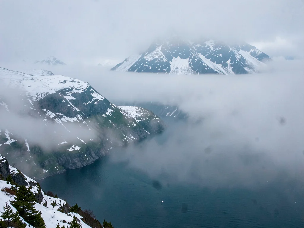 Snow on ridges visible through clearing mist