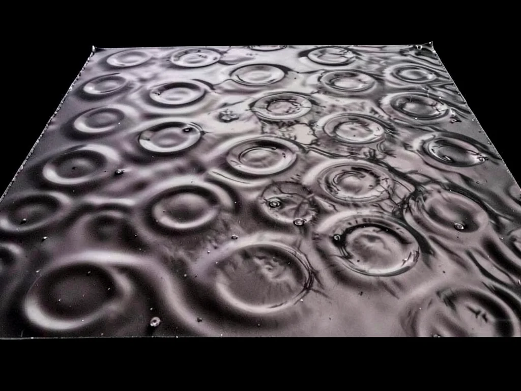 Liquid mercury pool showing subtle standing wave dimples