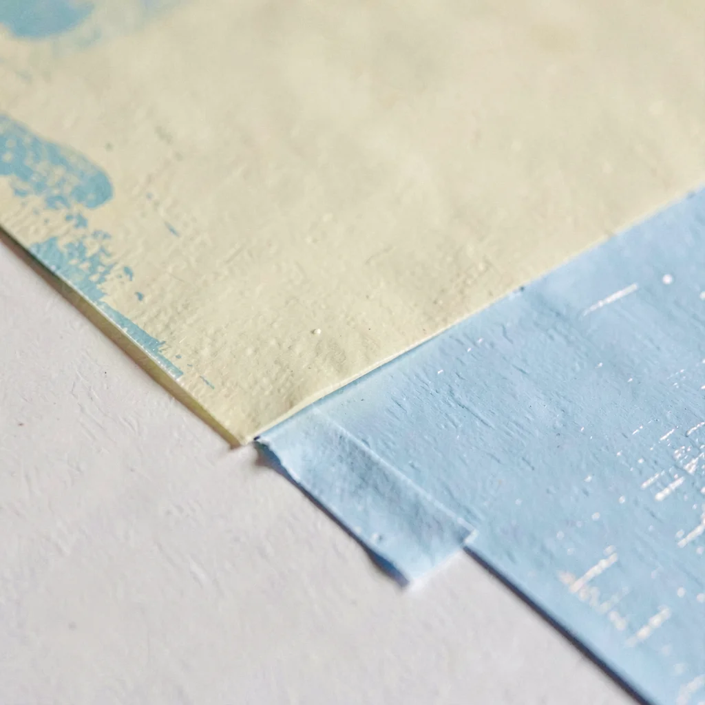 Surface study of a masking-tape edge against fresh paint, crisp line