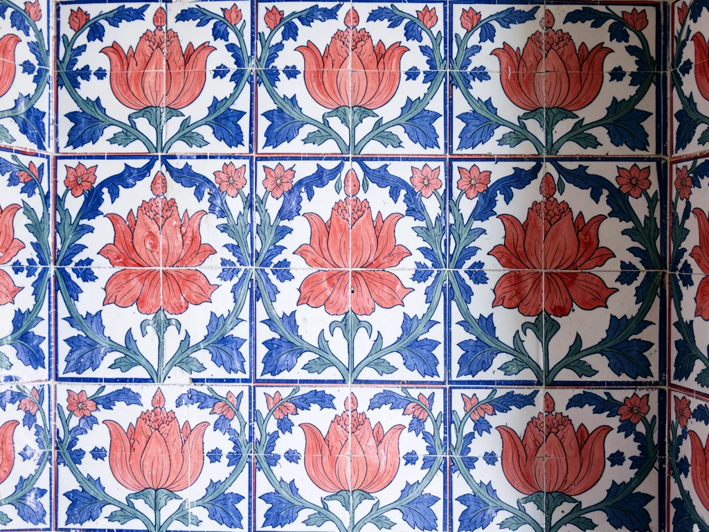Repeating tile wall detail from a mosque interior — offset panels, bold coral tu