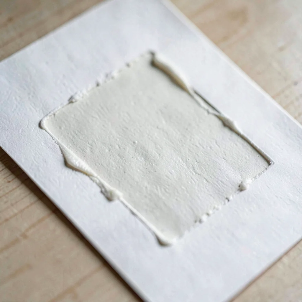 Paper macro of a single freshly pulled print laid flat, ink slightly raised on t