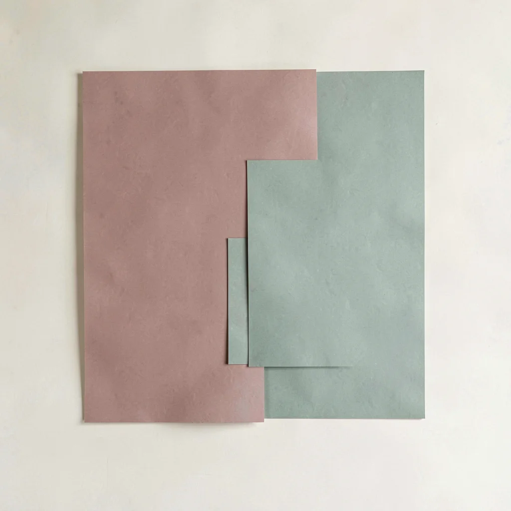 Color-block of two large overlapping rectangles in dusty rose and sage on a crea
