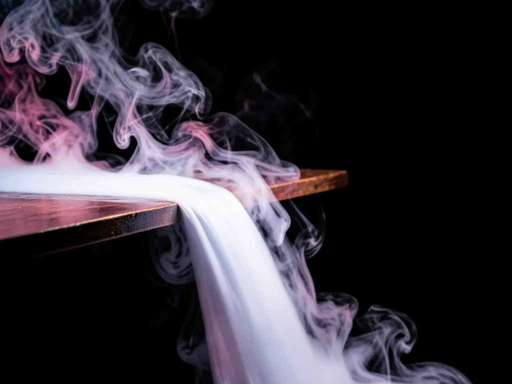 Liquid nitrogen vapor cascading over the edge of a table, the dense white fog fl