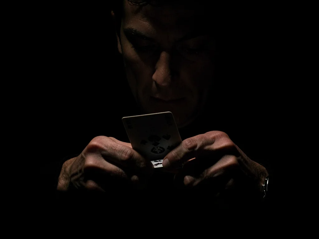 Hands dealing cards in darkness