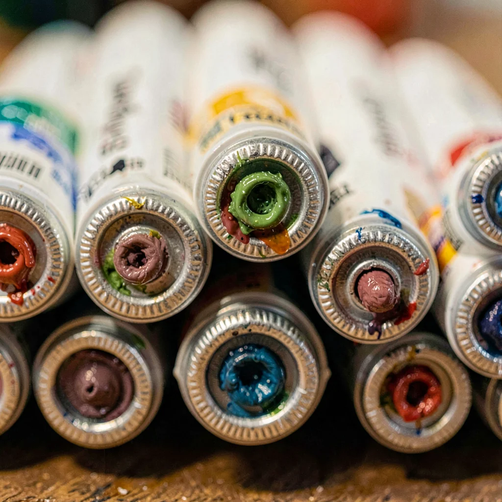 Macro of a stack of oil paint tubes seen end-on, crimped foil ends with pigment 