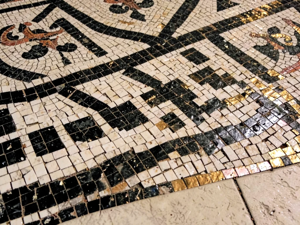 Close-up of an ancient Roman floor mosaic border — geometric meander pattern in 