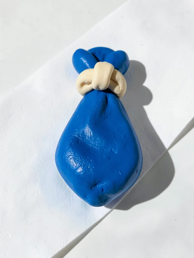 Snug chunky clay tie in cobalt blue with stubby cream-toned knot and oversized s