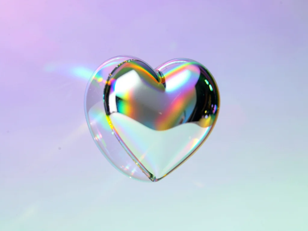 Levitating chrome heart catching a thin rainbow rim-light against a lavender-to-