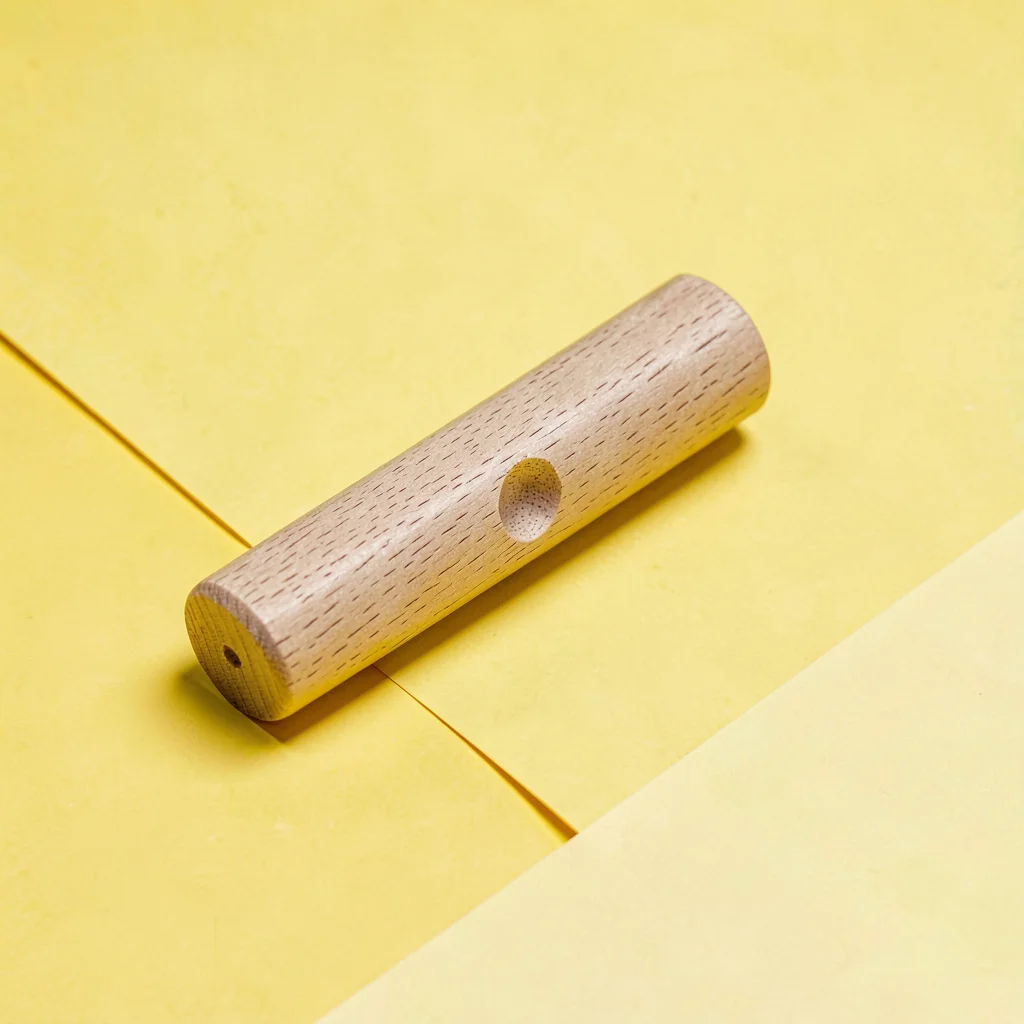 single hand-pressed wood-block-set printing roller resting at angle on a saturat