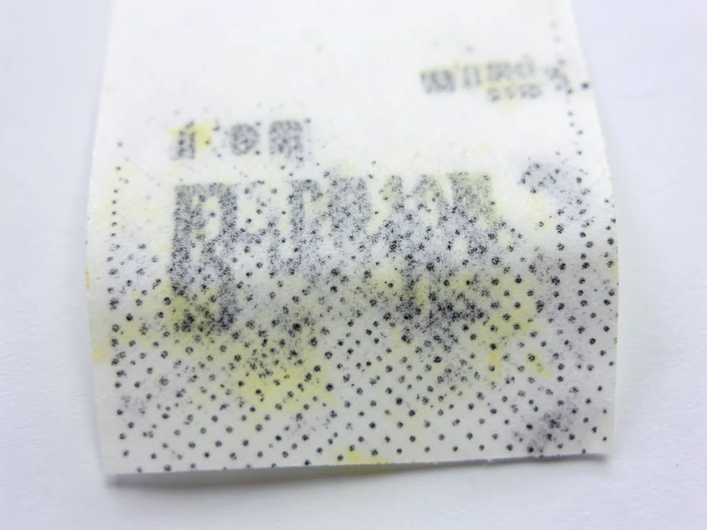 Single receipt extreme macro, thermal dot-matrix print pattern visible, dots fad