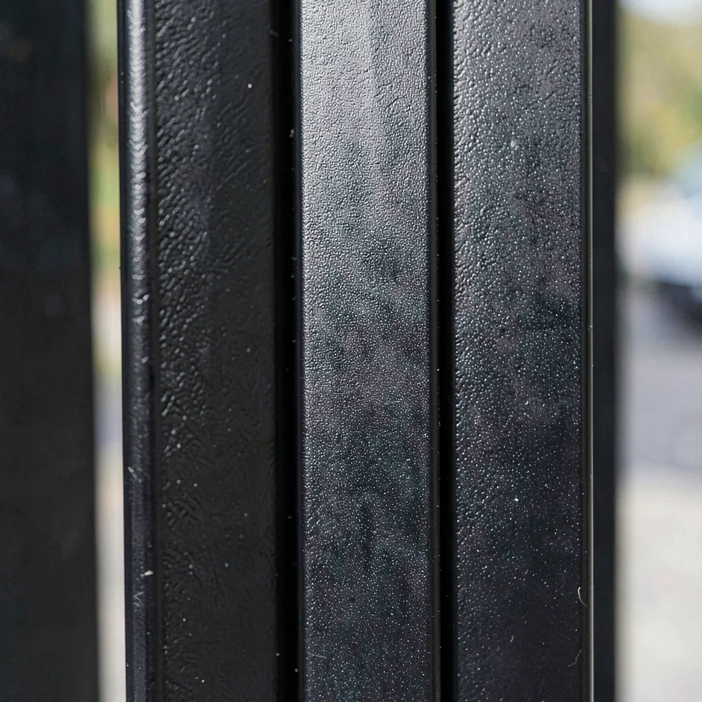 Tight crop of black aluminum fence pickets with a powder-coat satin finish and a