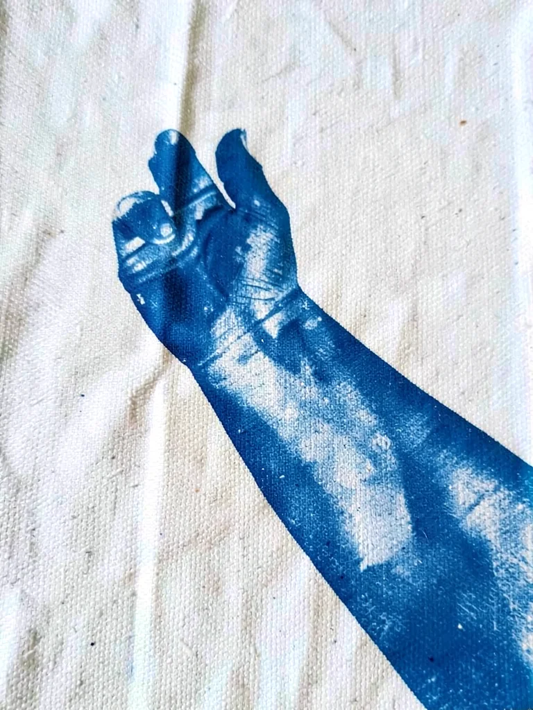 An elbow and forearm pressed at an angle — abstract blue form on textured fabric