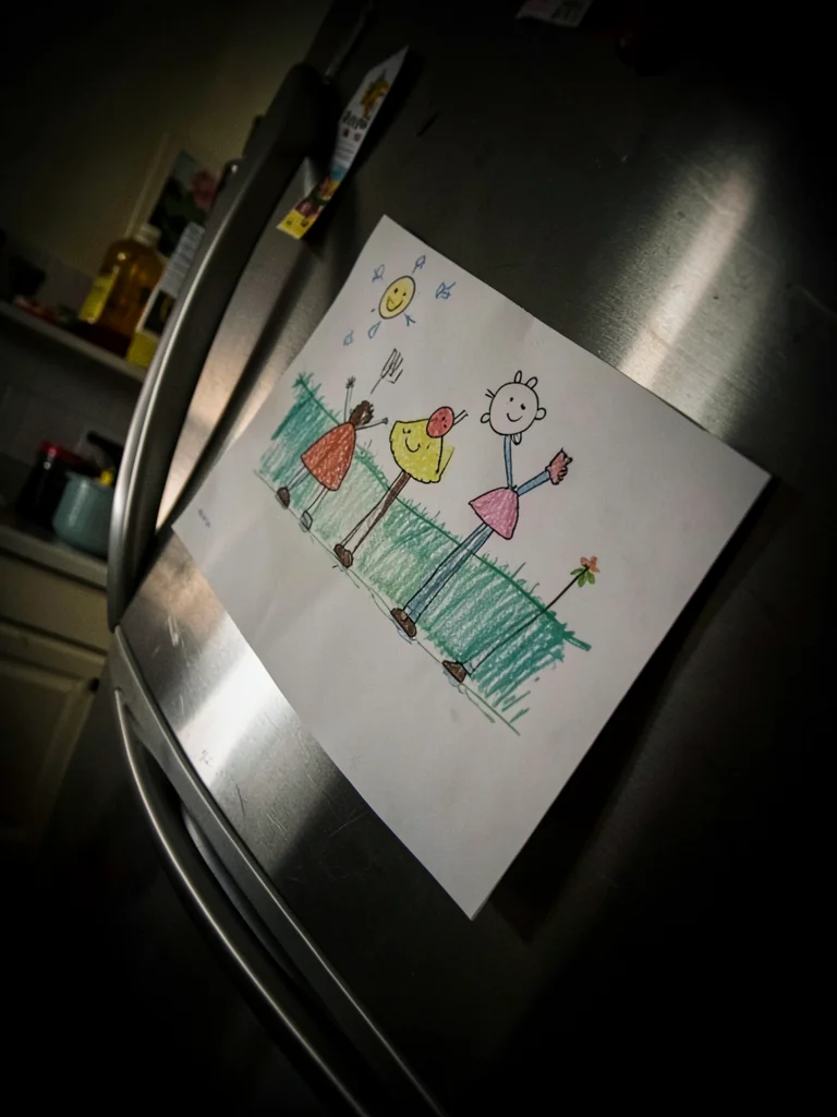 Child's drawing hung proudly on fridge, the perspective making cheerful into omi