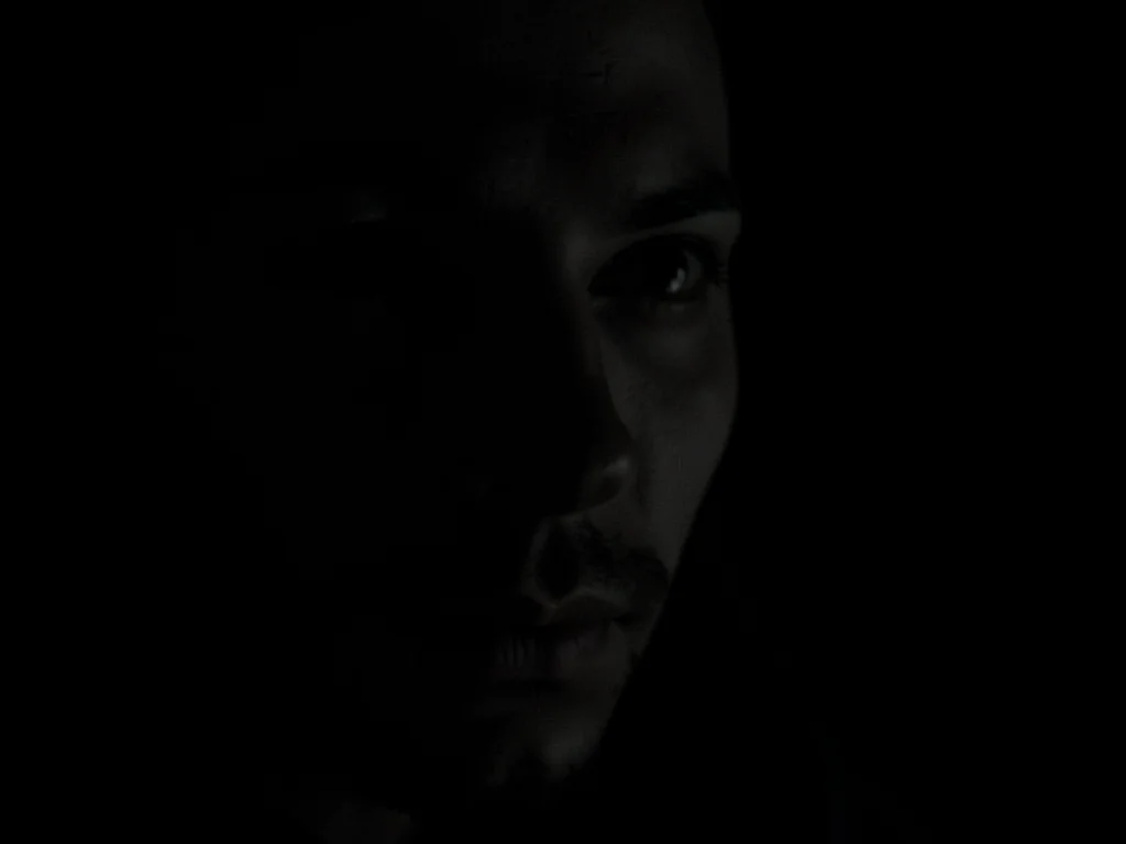 Face emerging from darkness partial