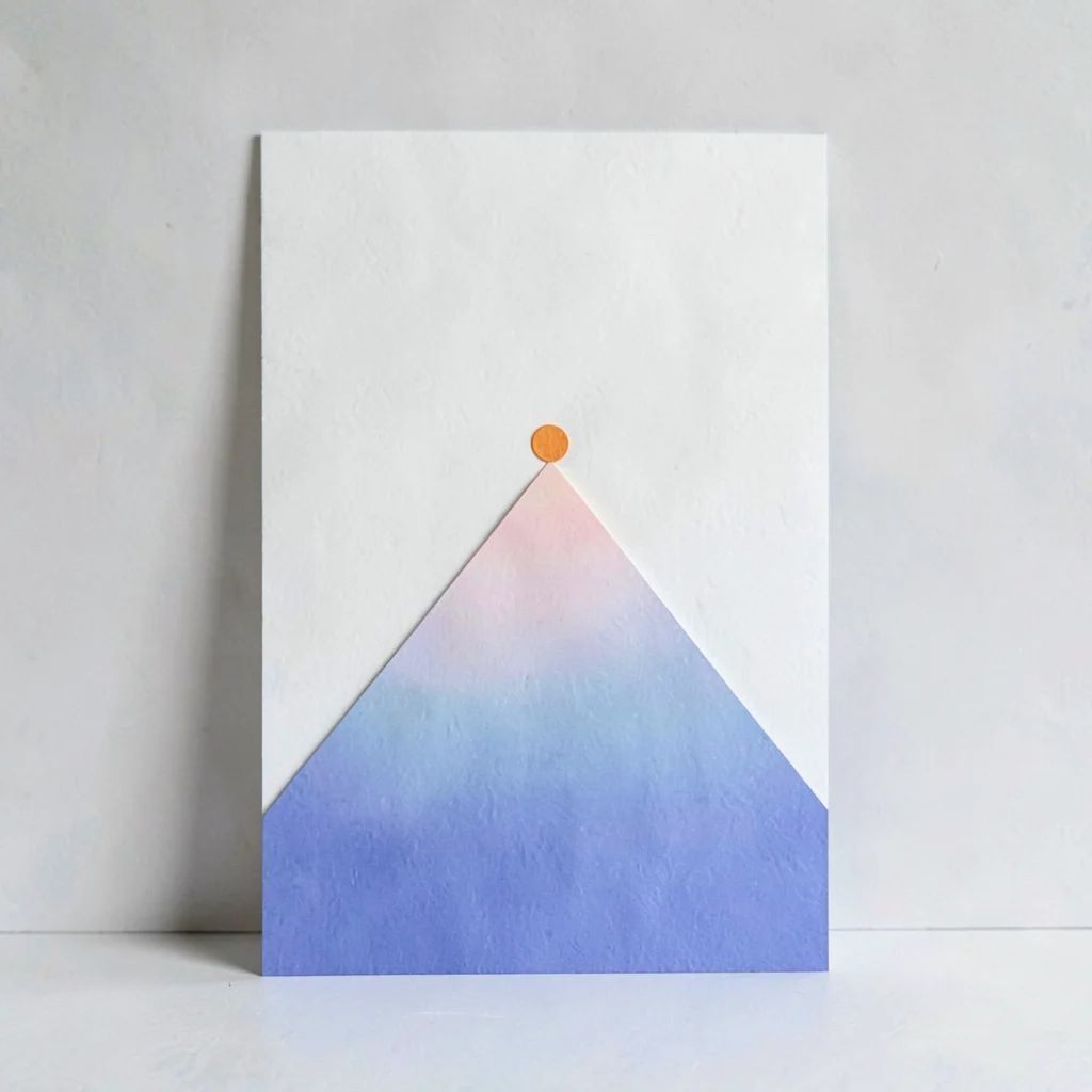 Vertical card with a cut-paper mountain shape and a tiny dot of warm orange at i
