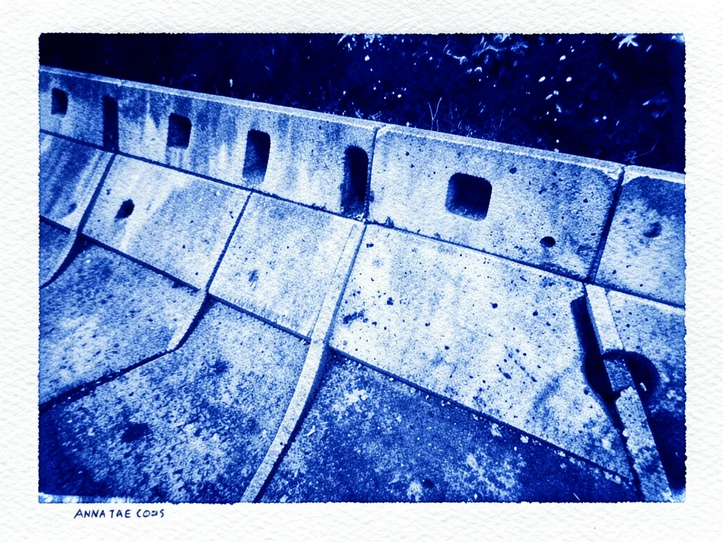 A concrete retaining wall with drainage weep holes in a geometric grid