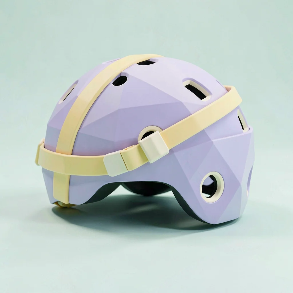 Strapped lavender lowpoly skateboard helmet with a chunky butter-yellow strap an