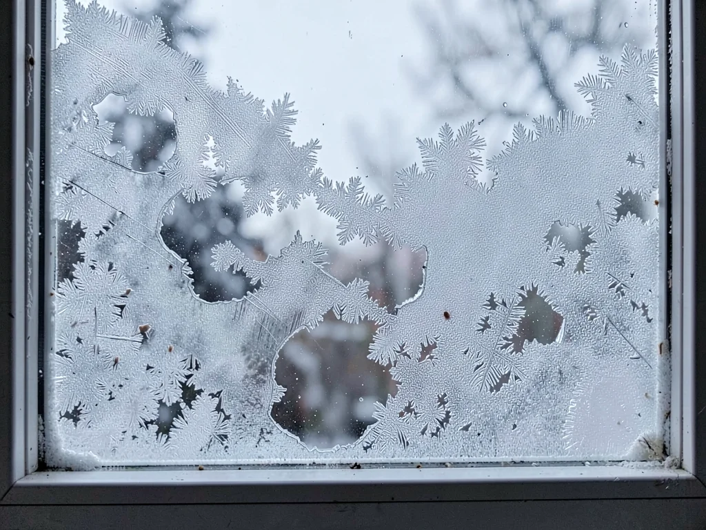 Breathing hole in morning window frost