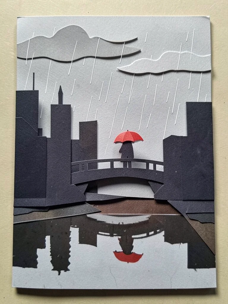 A rainy day city: grey sky with rain cut-outs, building silhouettes, a figure wi