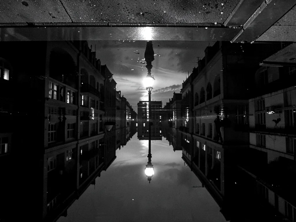 Street lamp creating pool of light reflections