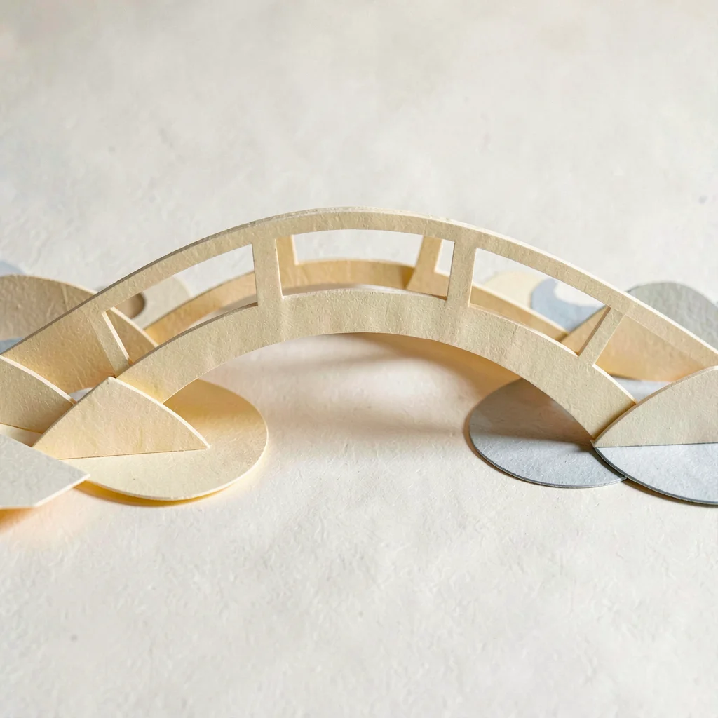 Papercraft motif of a paper-cut bridge arching over folded paper water, gentle d