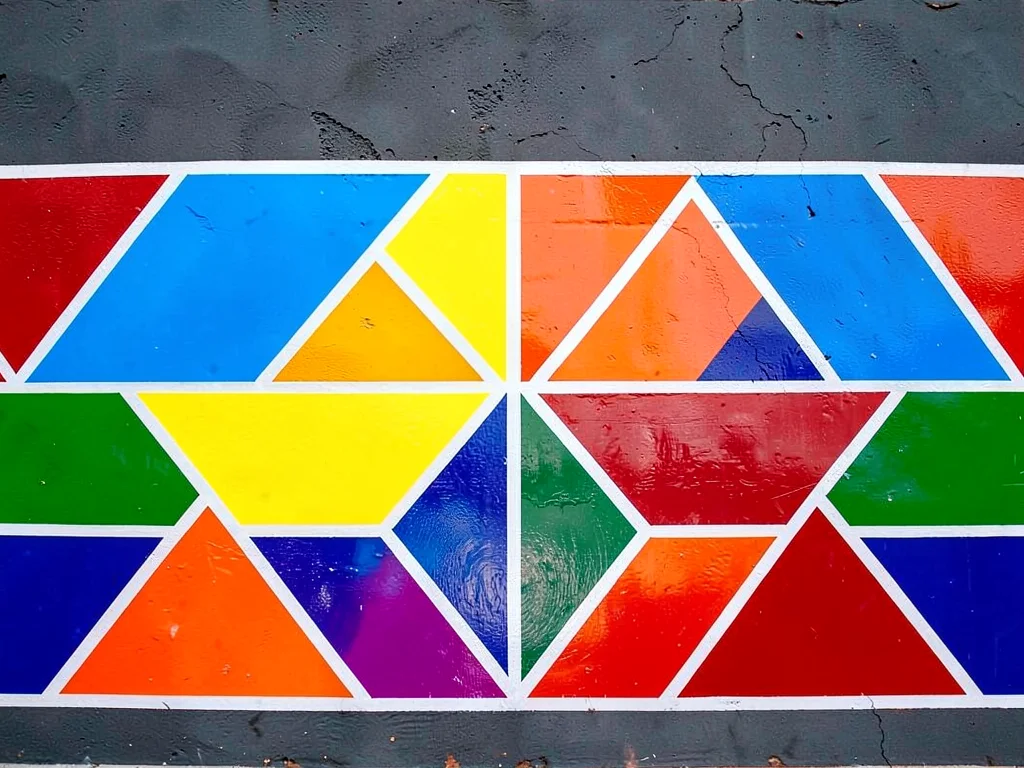 Detail of a painted wall — single horizontal band of bold color blocks and trian