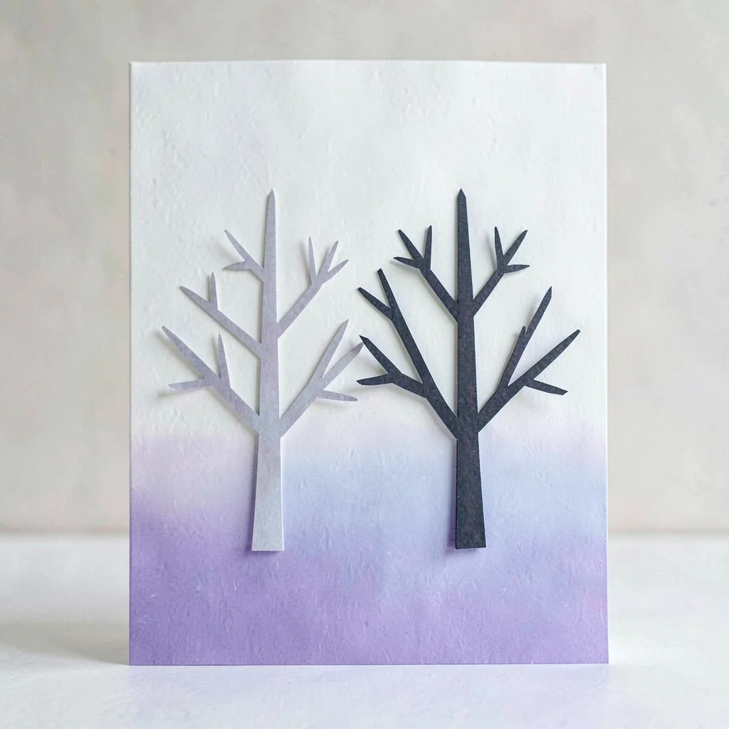 Vertical card with two cut-paper trees side by side, branches just touching, no 