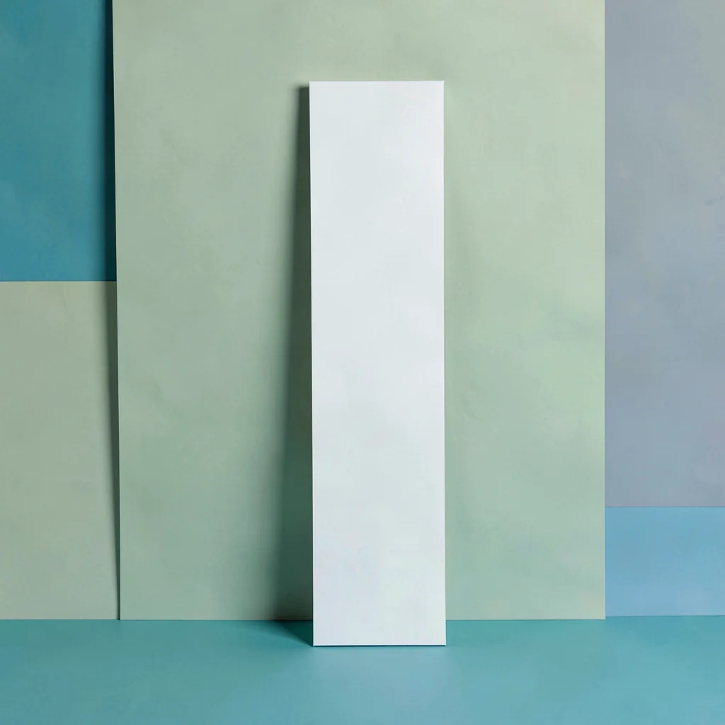 Vertical story-ratio composition of a tall edge restraint piece against a sage-g