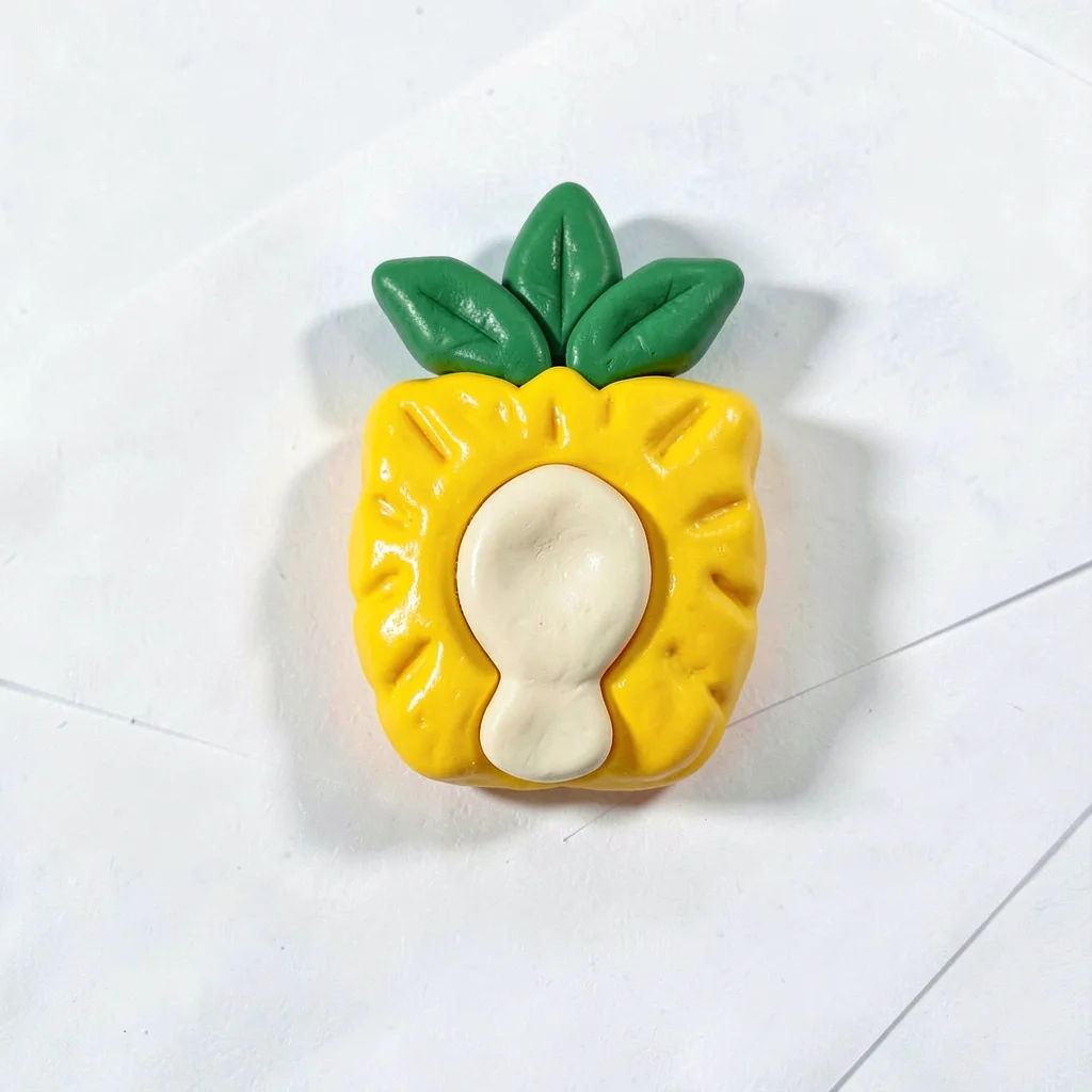 Sweet chunky clay slice of pineapple in primary yellow with stubby cream-toned c