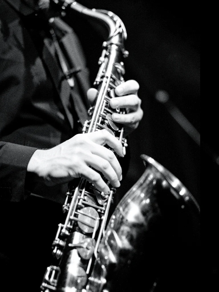 A jazz musician's hands on saxophone keys, fingers blurred with motion, the inst
