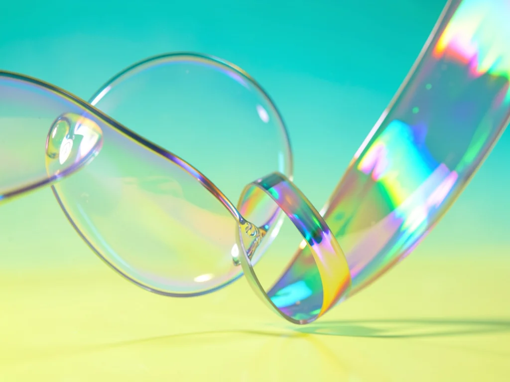 Oversized iridescent ribbon curling through frame on a tropical aqua-yellow grad