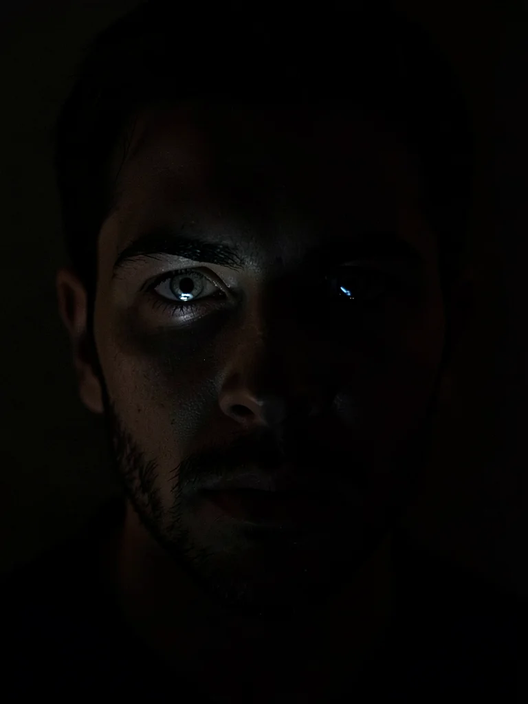 Face lit only by phone screen in darkness, conversation clearly bad news, eyes c