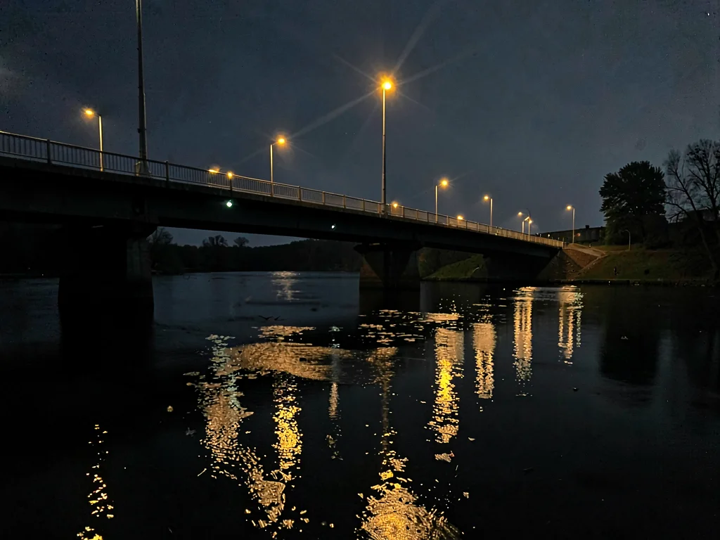 Bridge lights reflected in darkening water