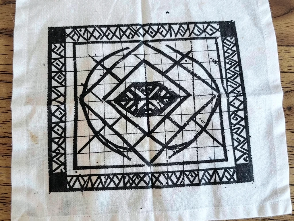 Mmusuyidee symbol stamped on white cotton — luck symbol in precise grid repetiti