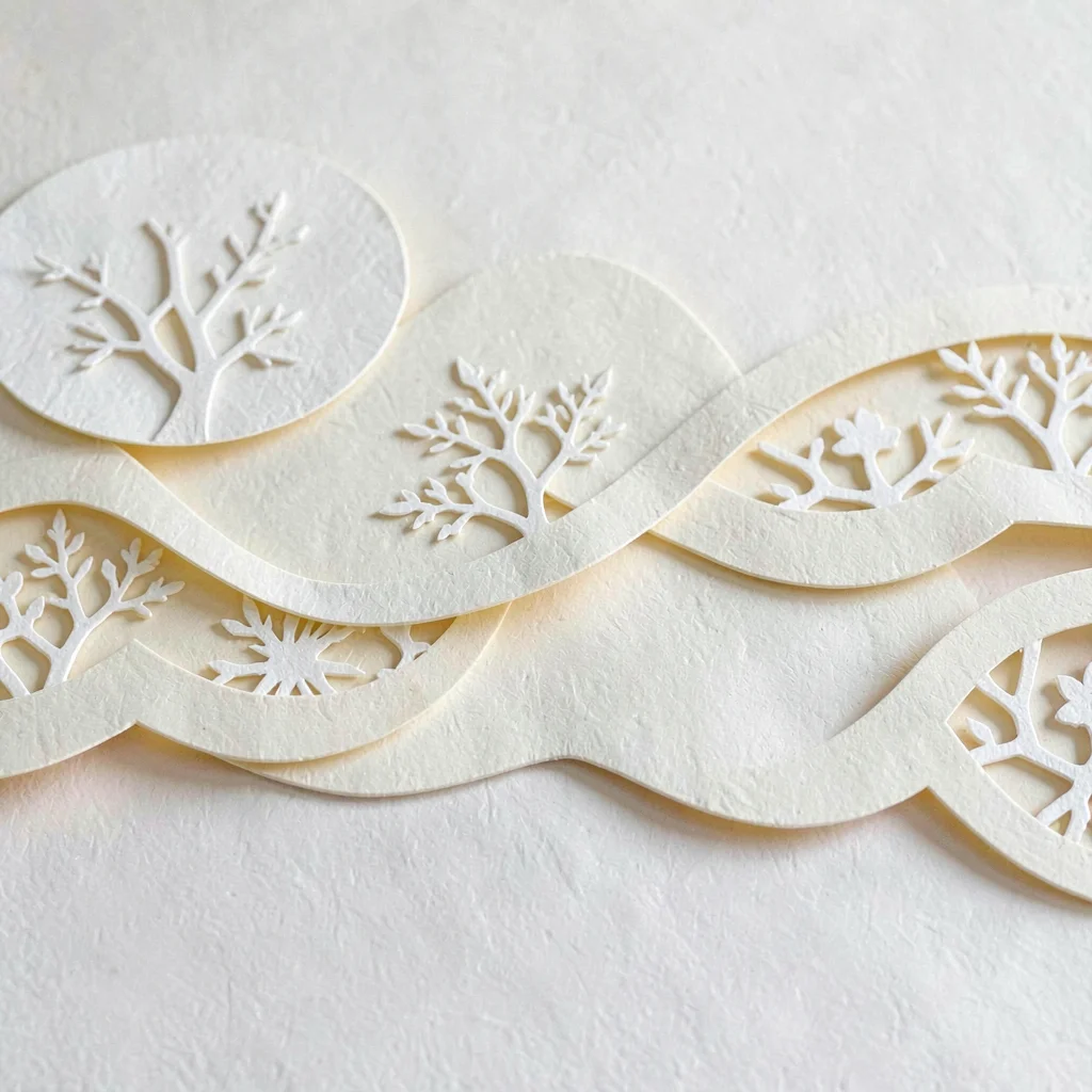 Papercraft motif of paper-cut prints layered across cream paper waves, soft butt