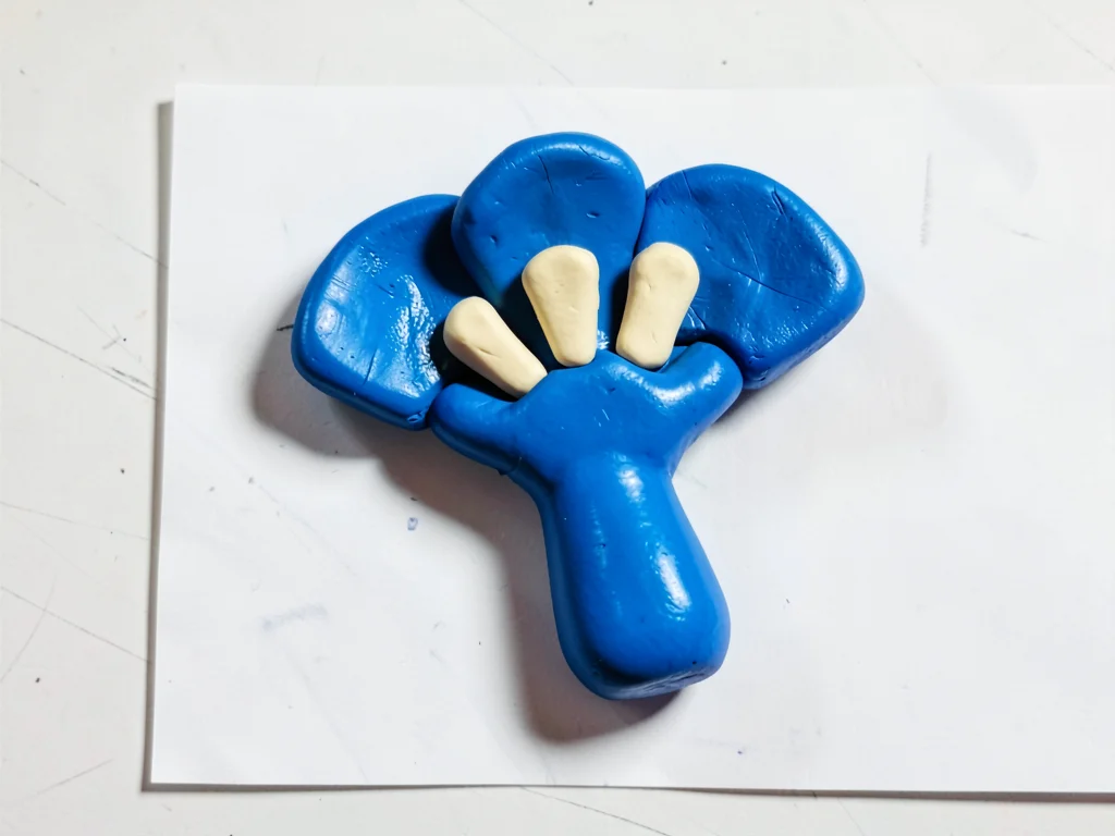 Whirring chunky clay handheld fan in primary blue with stubby cream-toned blades