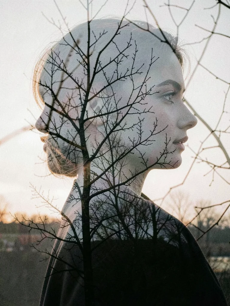 Woman's profile merged with bare winter branches, her thoughts visible as tangle