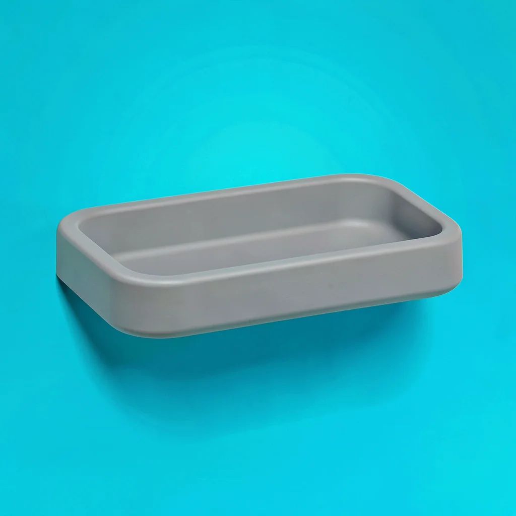 single matte-grey shower-shelf in moulded silicone top-down on a vivid teal back