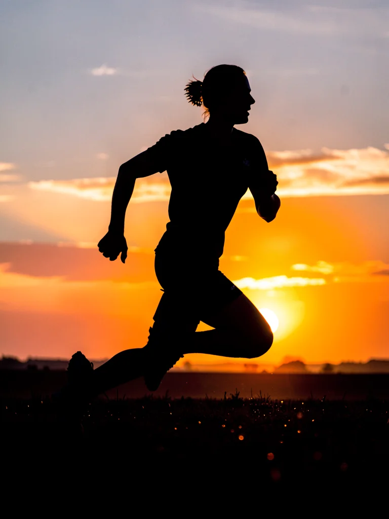 Runner silhouetted against sunrise