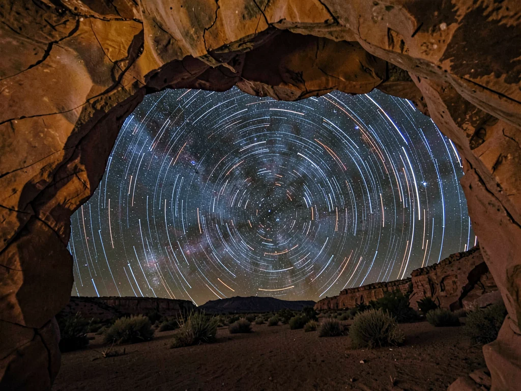 Star trails through natural arch frame