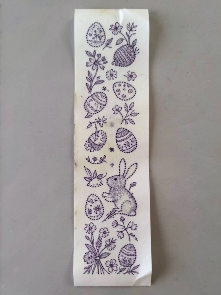 A long receipt printed with a continuous Easter scene — the thermal dots forming