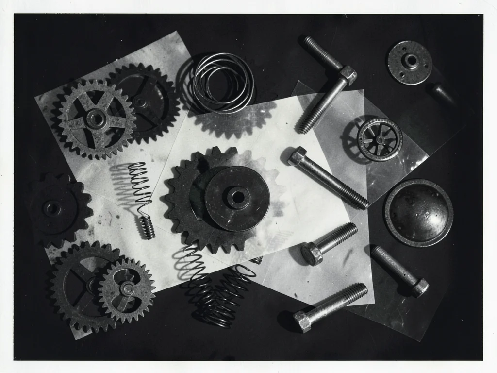 A collection of industrial objects — gears, springs, bolts — arranged for photog