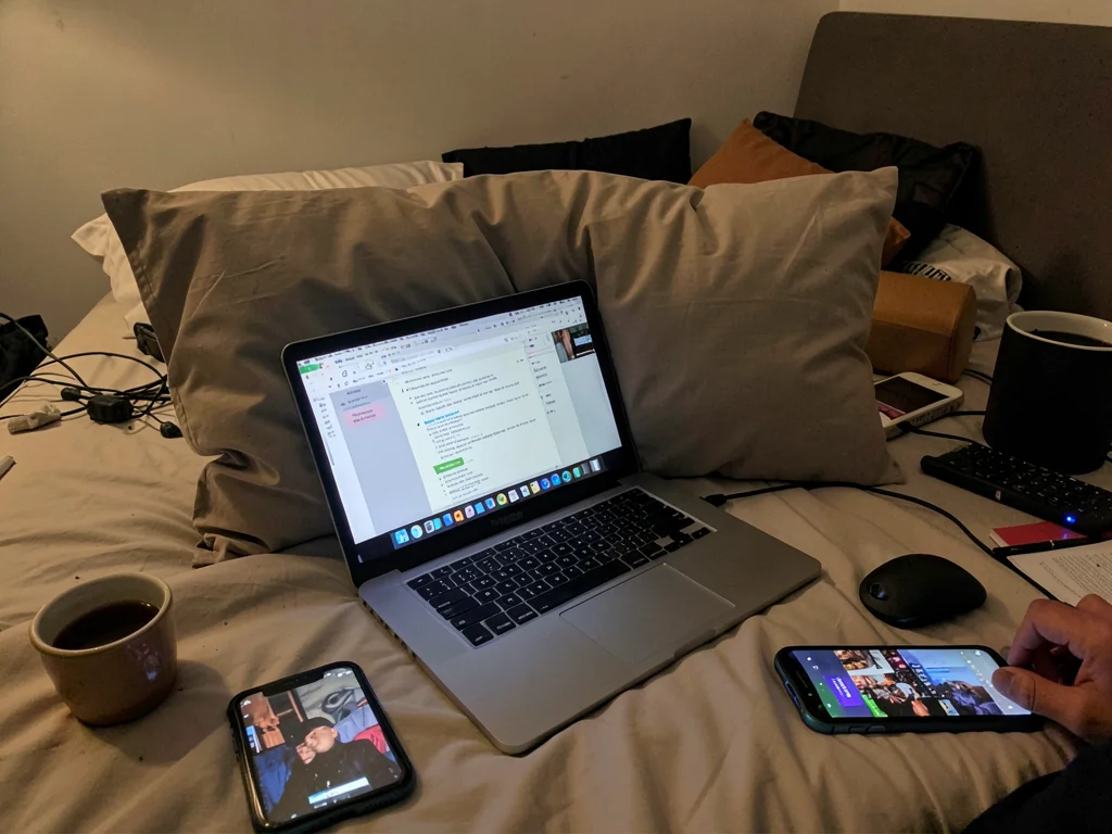 Laptop in bed with pillow barrier, work document and Netflix competing