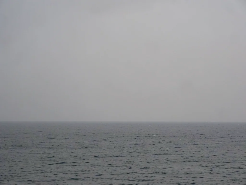 Horizon line only, grey sky meeting grey sea, the negotiation between elements