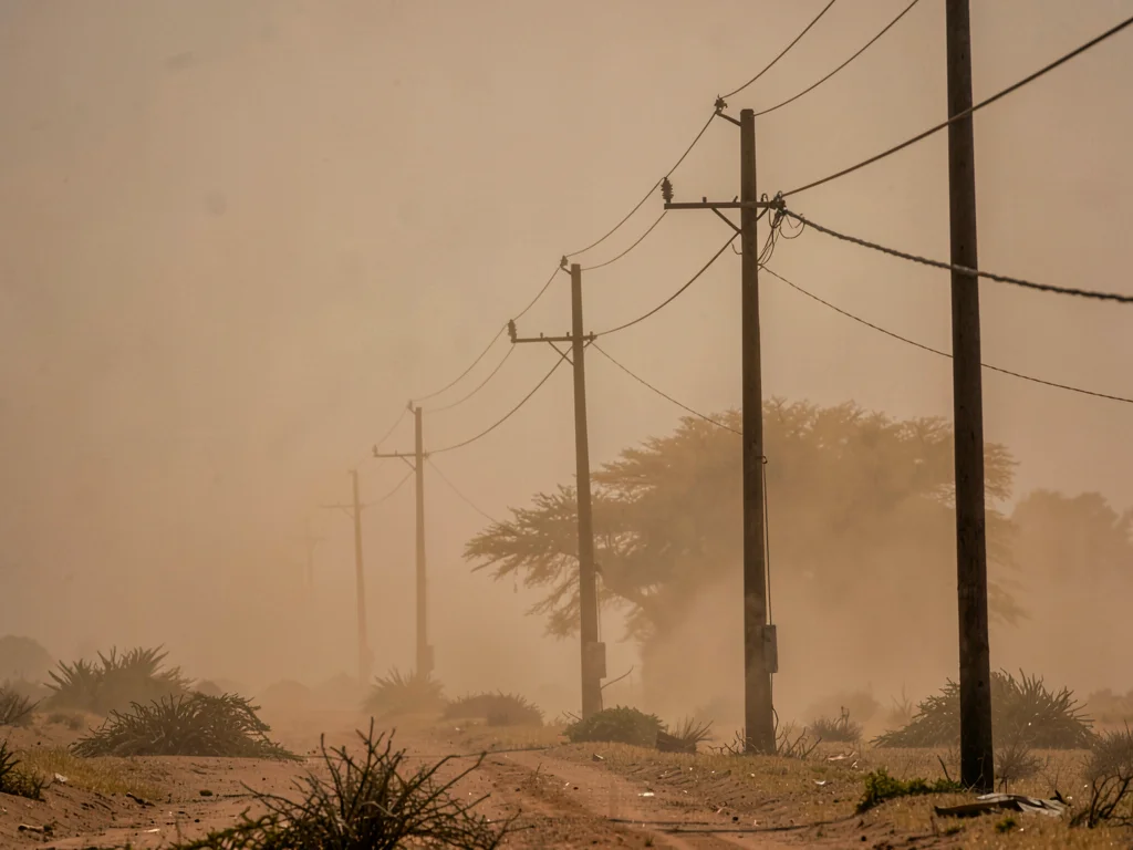 Telephone poles creating rhythm into vanishing dust